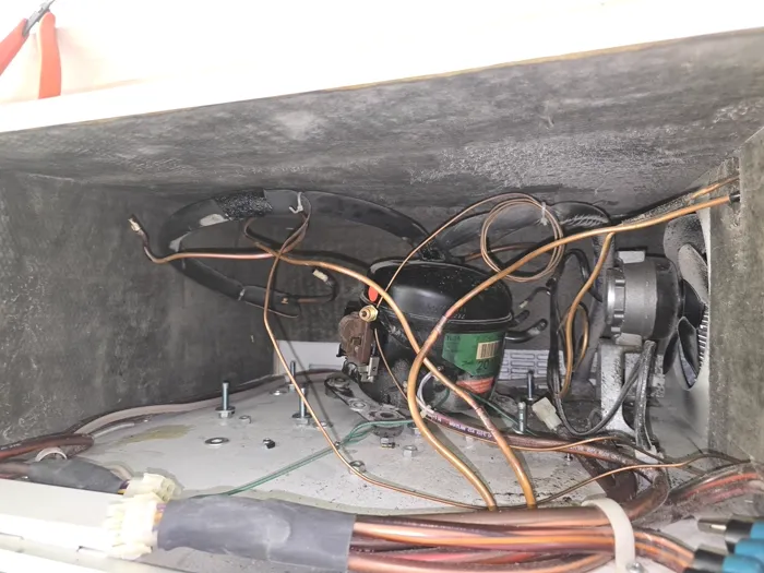 Technician brazing a refrigerant line on a built-in refrigerator column