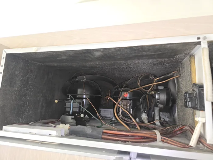 Technician repairing a pulled-out wall oven