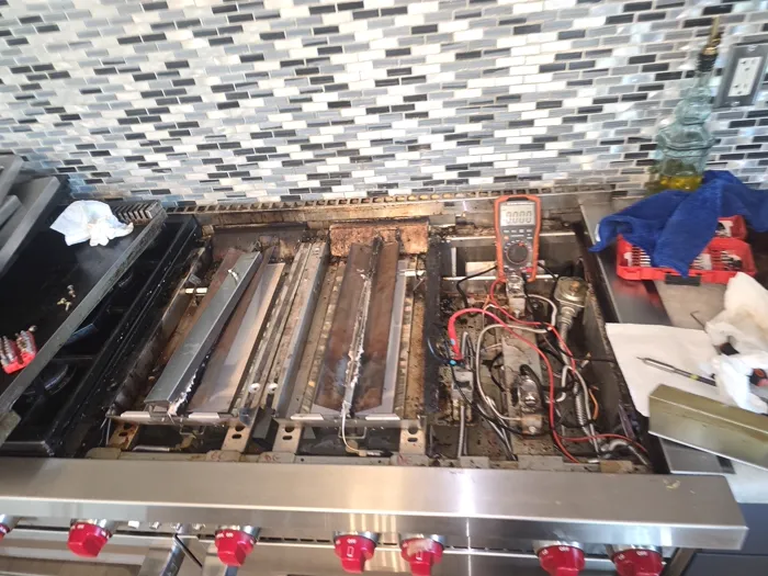 Technician testing a gas range with a multimeter
