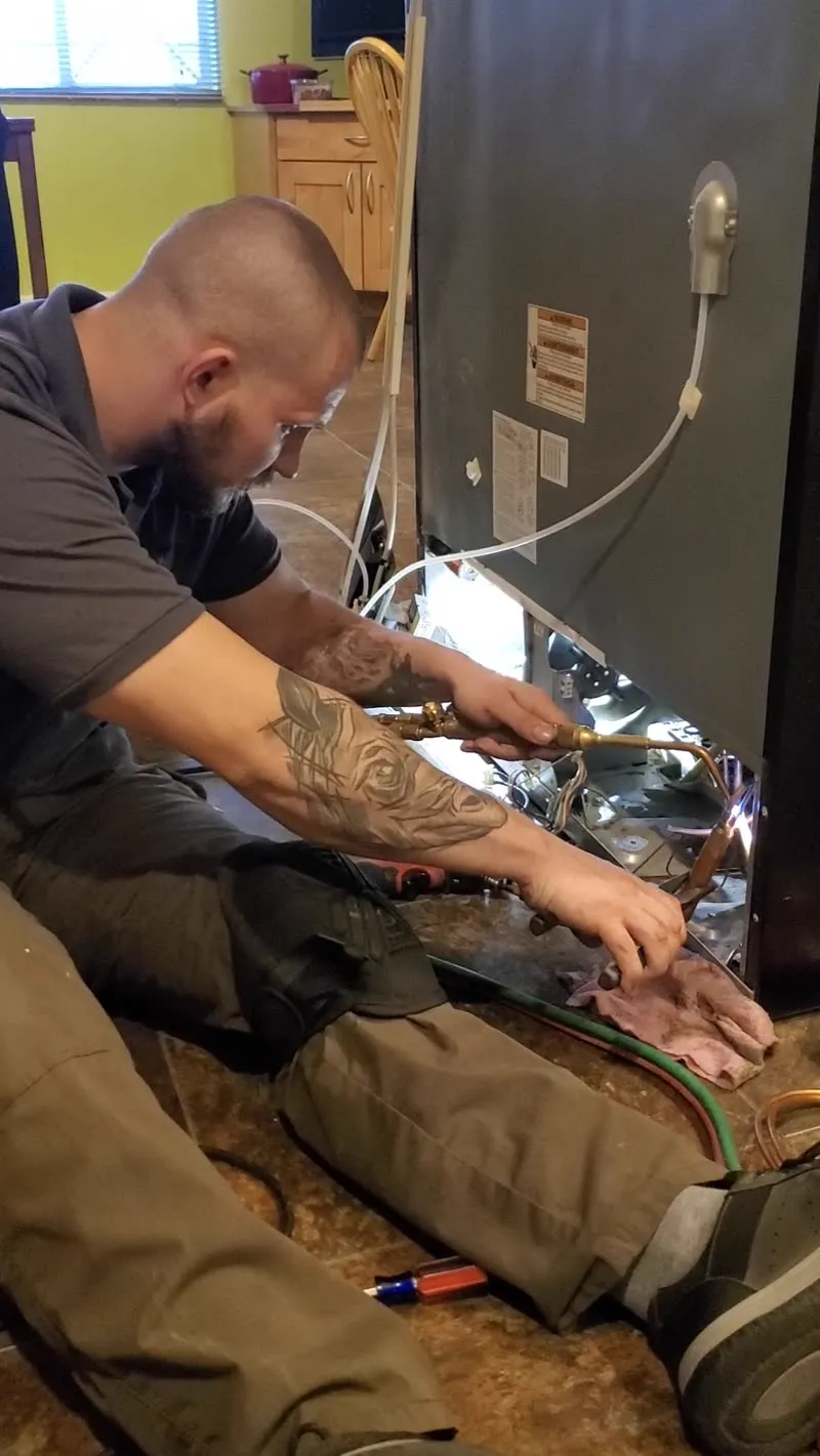 ProMaster technician repairing an appliance